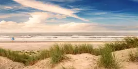 Weiße Dünen vor weitem Strand an der Nordsee