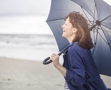 Frau mit Regenschirm am Strand auf Föhr