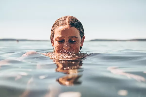 Urlauberin schwimmt allein im Meer