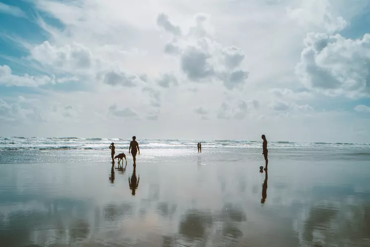 Urlauber mit Hund und Ball am weiten Nordseestrand