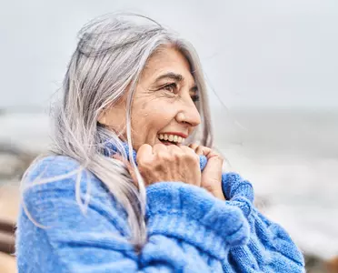 Ältere Urlauberin in warmen Pullover am Strand von Langeoog