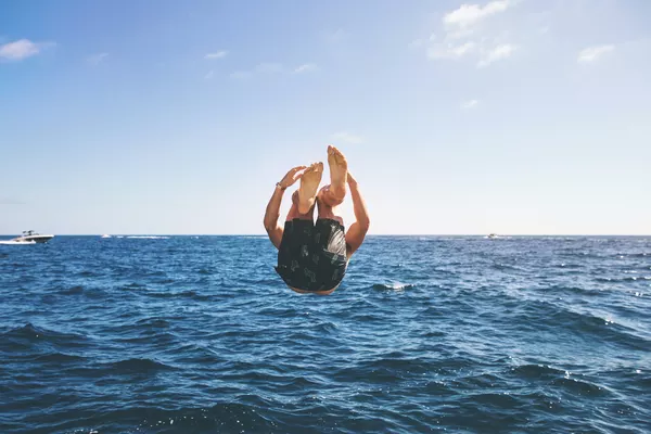 Junger Urlauber springt mit einem Salto in die Ostsee