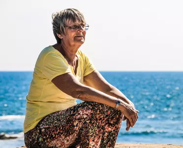 Frau hockt am Strand der Ostsee